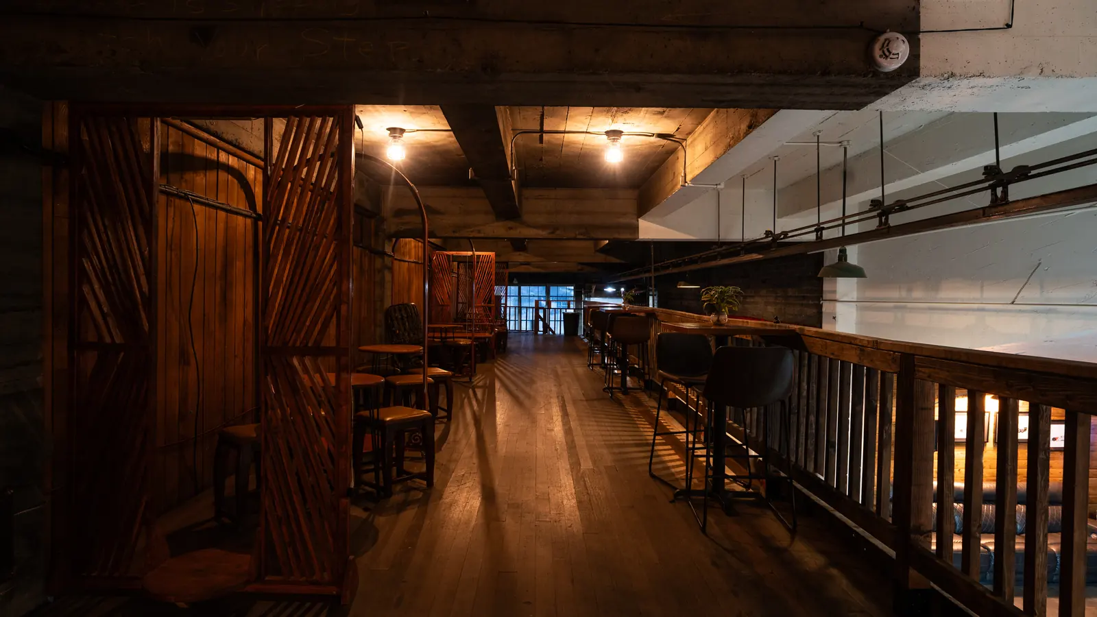 The wood balcony walkway with booths that wraps the Speakeasy at 1712 Studios